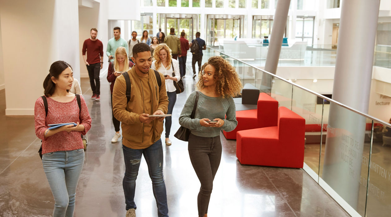Students walk and talk using mobile devices in university
