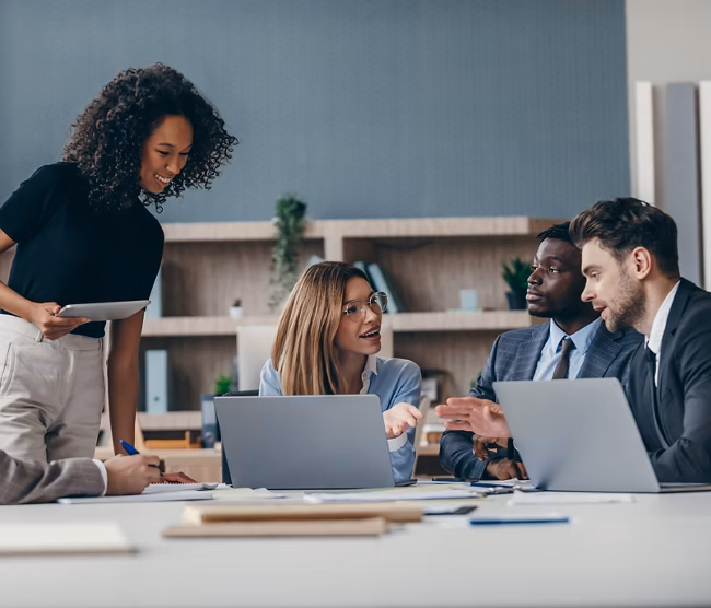 Confident group of business people discussing strategy during team meeting at the office desk 