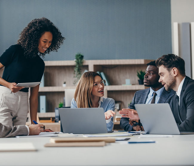 Confident group of business people discussing strategy during team meeting at the office desk 