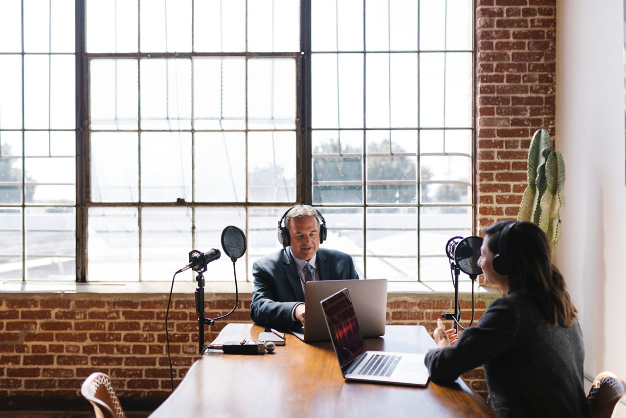 Female broadcaster interviewing her guest in a studio