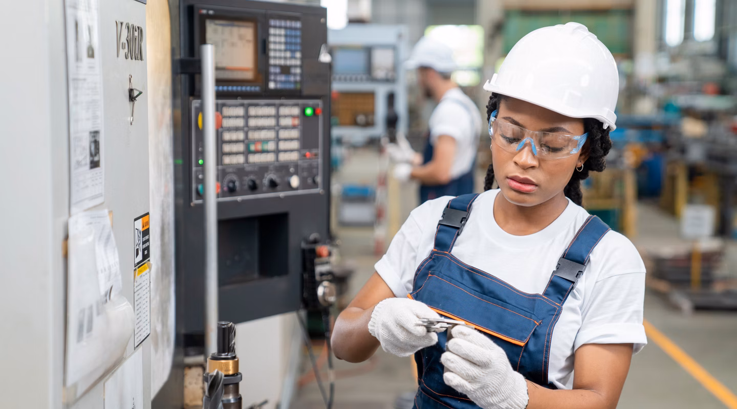 Female Engineer Programming A CNC Machine At Factory