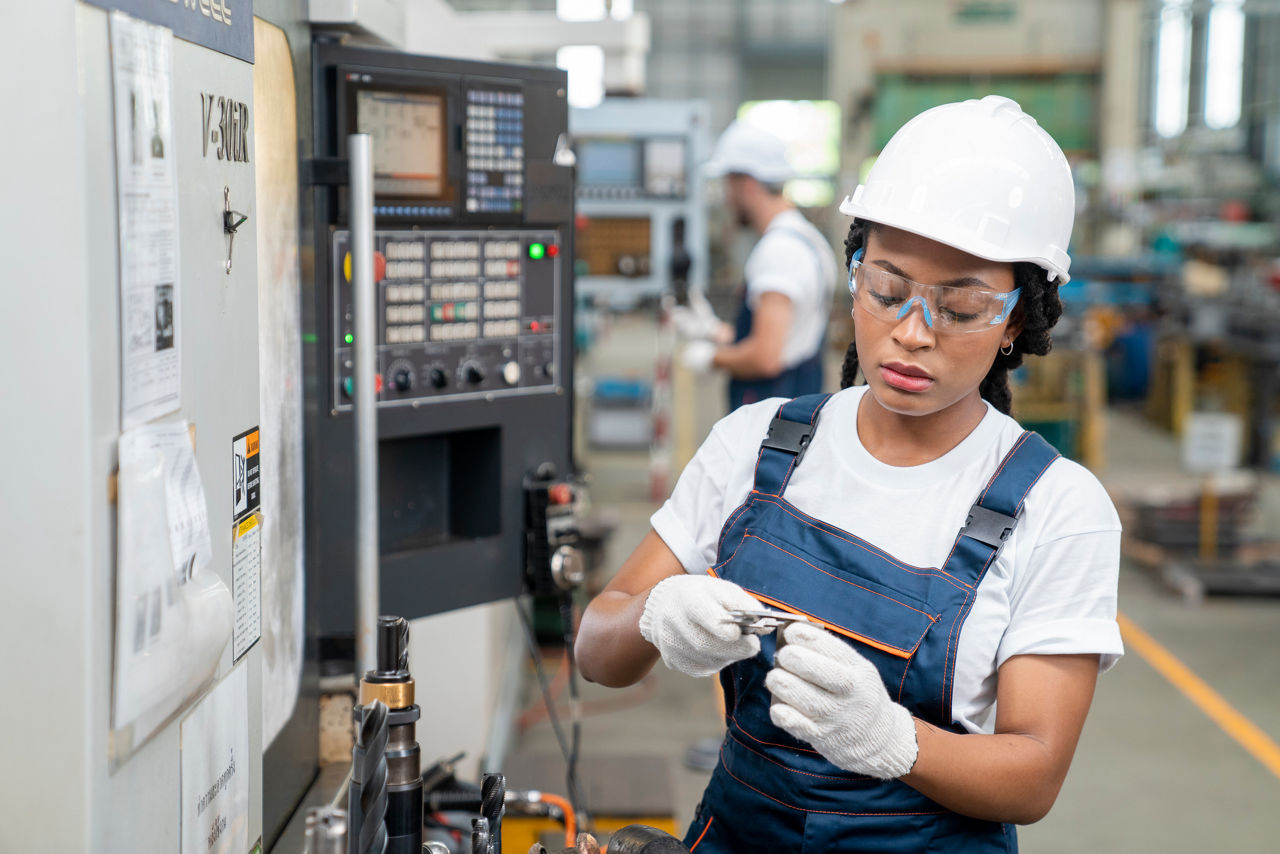 Female Engineer Programming A CNC Machine At Factory