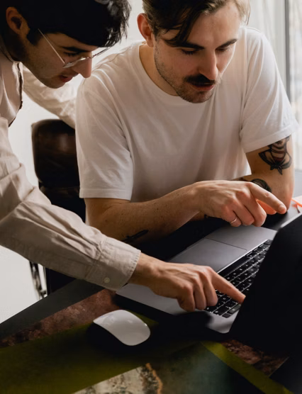 person working with a coworker pointing at their computer