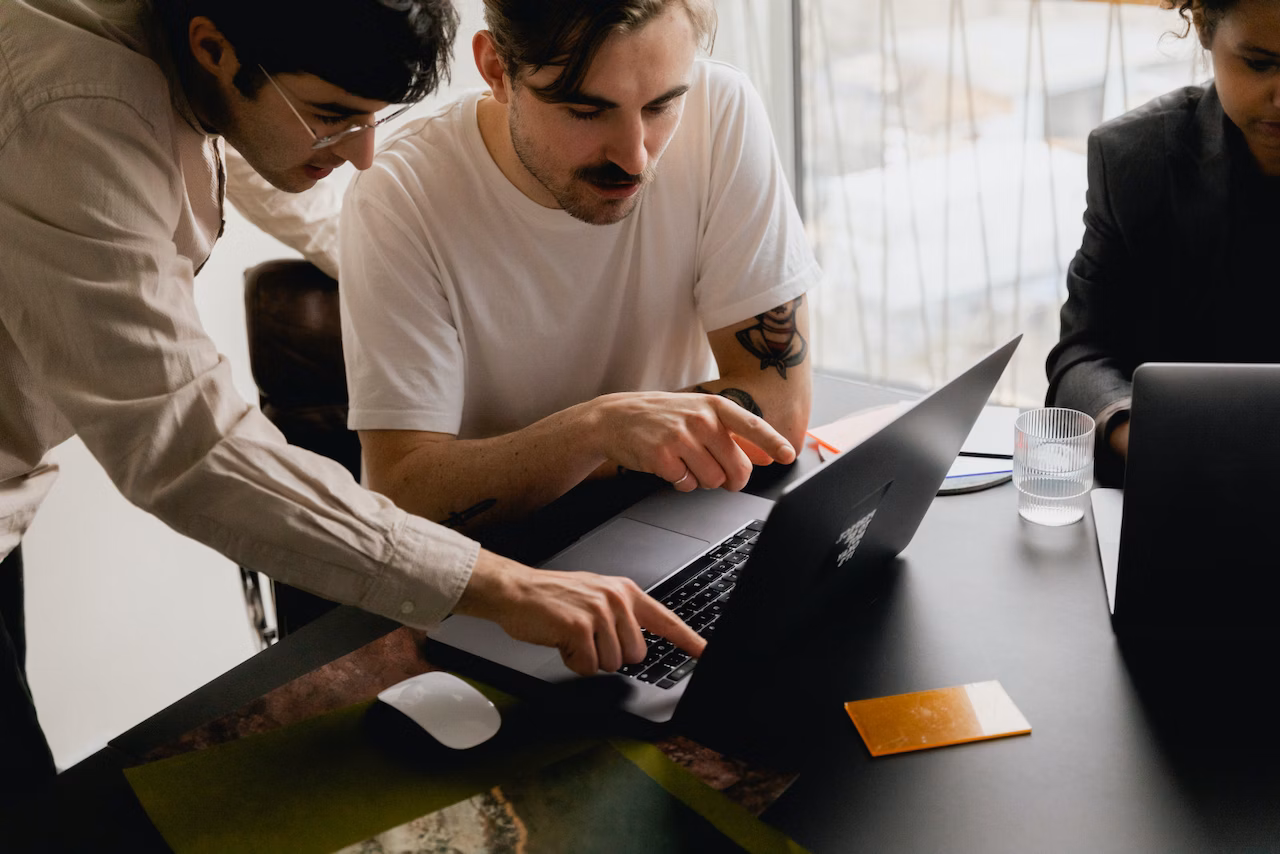 person working with a coworker pointing at their computer