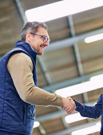 Shot of two people shaking hands in a large warehouse.