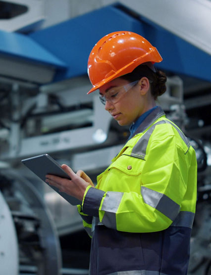 woman in hard hat looking at tablet