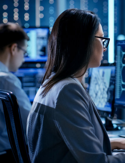 People working on two computers side by side