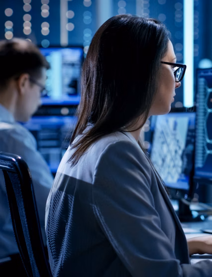 People working on two computers side by side