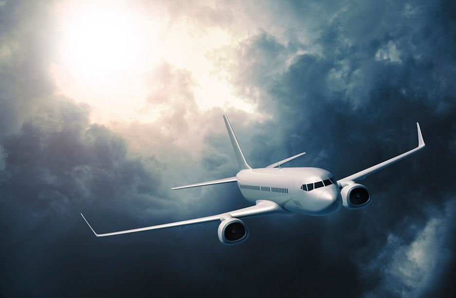 Mid-sized passanger airplane flying in stormy clouds.