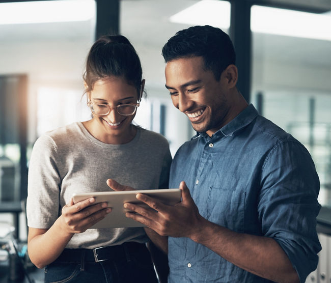 Shot of two young workers using a digital tablet in a modern office.