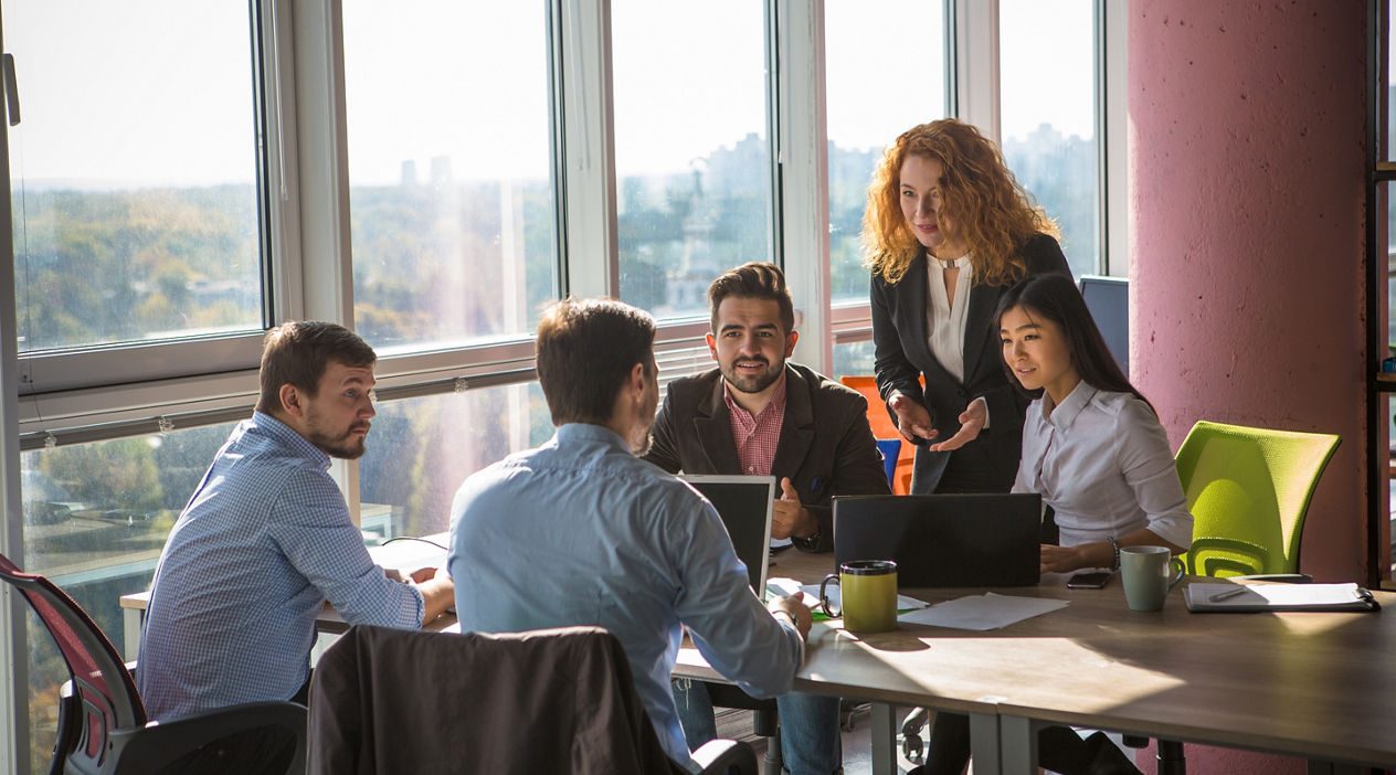 Business people listening to one of their colleague bad or good news for their company, enterprise or firm while working round table in board room in office.
