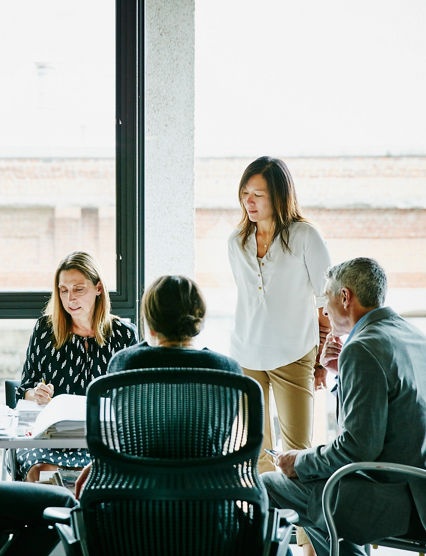 Businesswoman leading planning meeting at office workstation