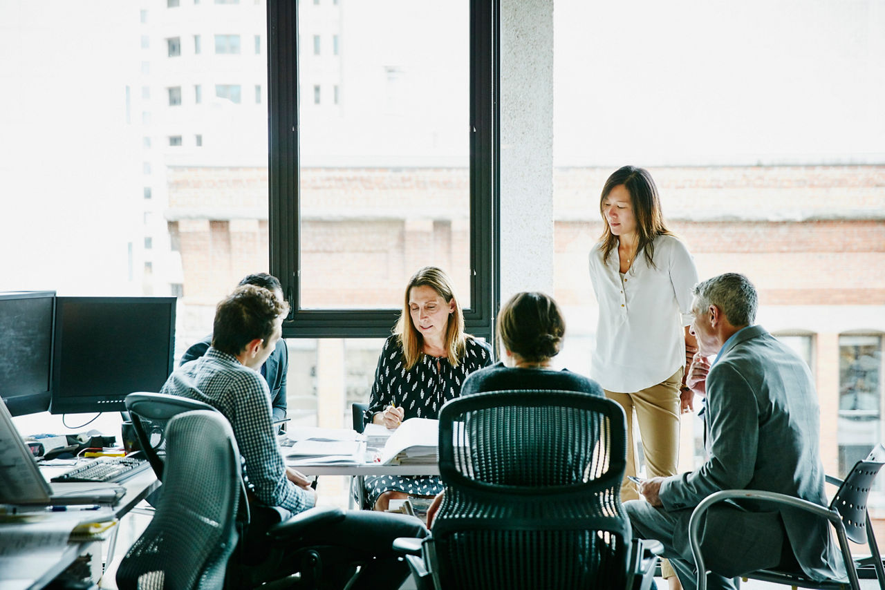 Businesswoman leading planning meeting at office workstation