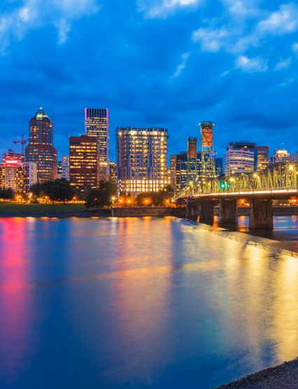 Skyline of Portland, Oregon, USA at dusk, with Willamette River and Hawthorne Bridge.