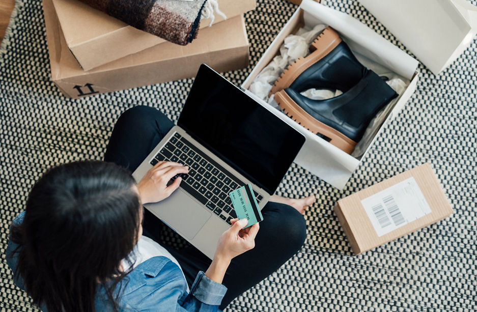 High angle view of a young Asian woman shopping online on laptop, making payment with credit card. Enjoying Seasonal sales. Shopaholic concept.