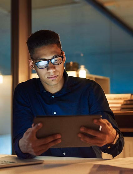 Shot of a young businessman using a digital tablet during a late night at work