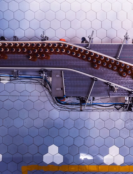 Industry, Business, Factory, Bottling Plant - Bottles Filled with Fresh Drink Moving on a Conveyor Belt to the Packaging Section of a Factory.
