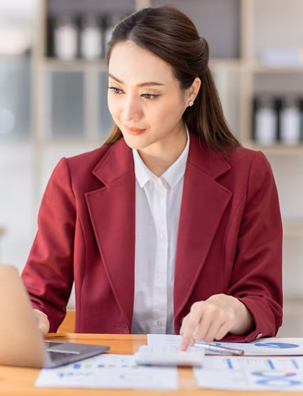 Asian woman working laptop in workplace, Business woman wearing red jacket suit busy working on laptop computer checking finances, investment, economy, saving money or insurance concept
