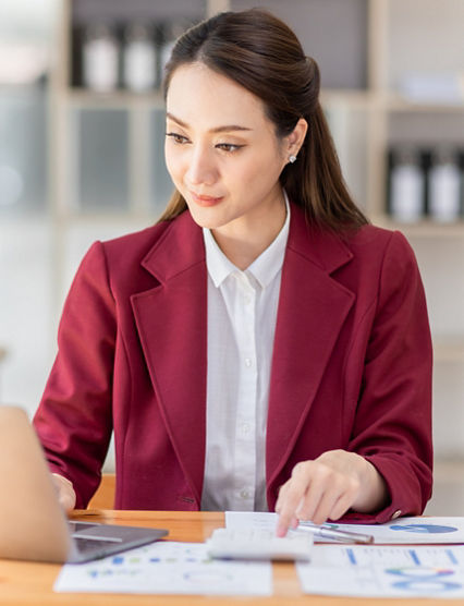 Asian woman working laptop in workplace, Business woman wearing red jacket suit busy working on laptop computer checking finances, investment, economy, saving money or insurance concept