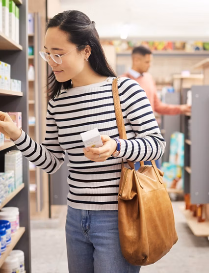 Asian woman, retail shopping and shelf in store for products, grocery stock and choice of brands. Female shopper, customer and supermarket aisle for groceries, sales decision and consumer buying.