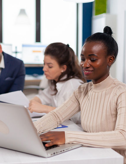 African business owner entrepreneur planing strategy in briefing conference planing company room. Diverse colleagues working in background. Multiethnic coworkers planning new financial project.
