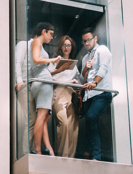 Picture of young attractive businesspeople talking in elevator