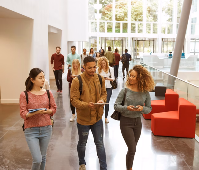 Students walk and talk using mobile devices in university