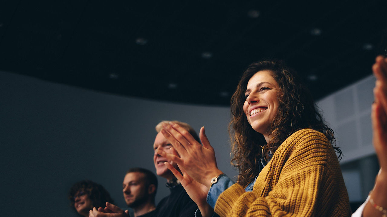 woman clapping in an audience 