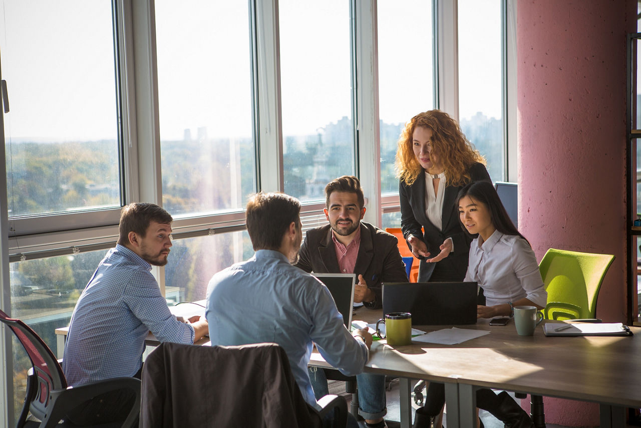 Business people listening to one of their colleague bad or good news for their company, enterprise or firm while working round table in board room in office.