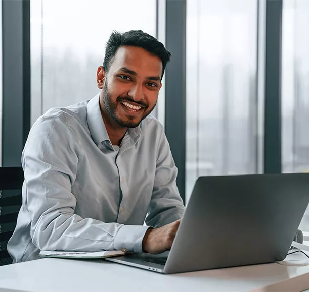 Beautiful indian man is working in the office by laptop.