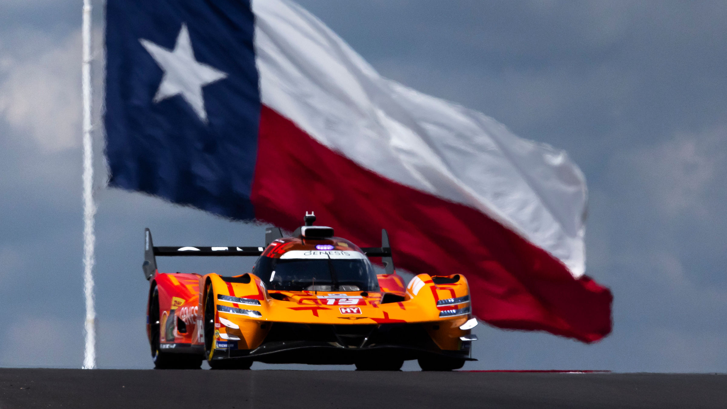 Genesis GMR-001 passes beneath a towering Texas flag at COTA during Lone Star Le Mans.