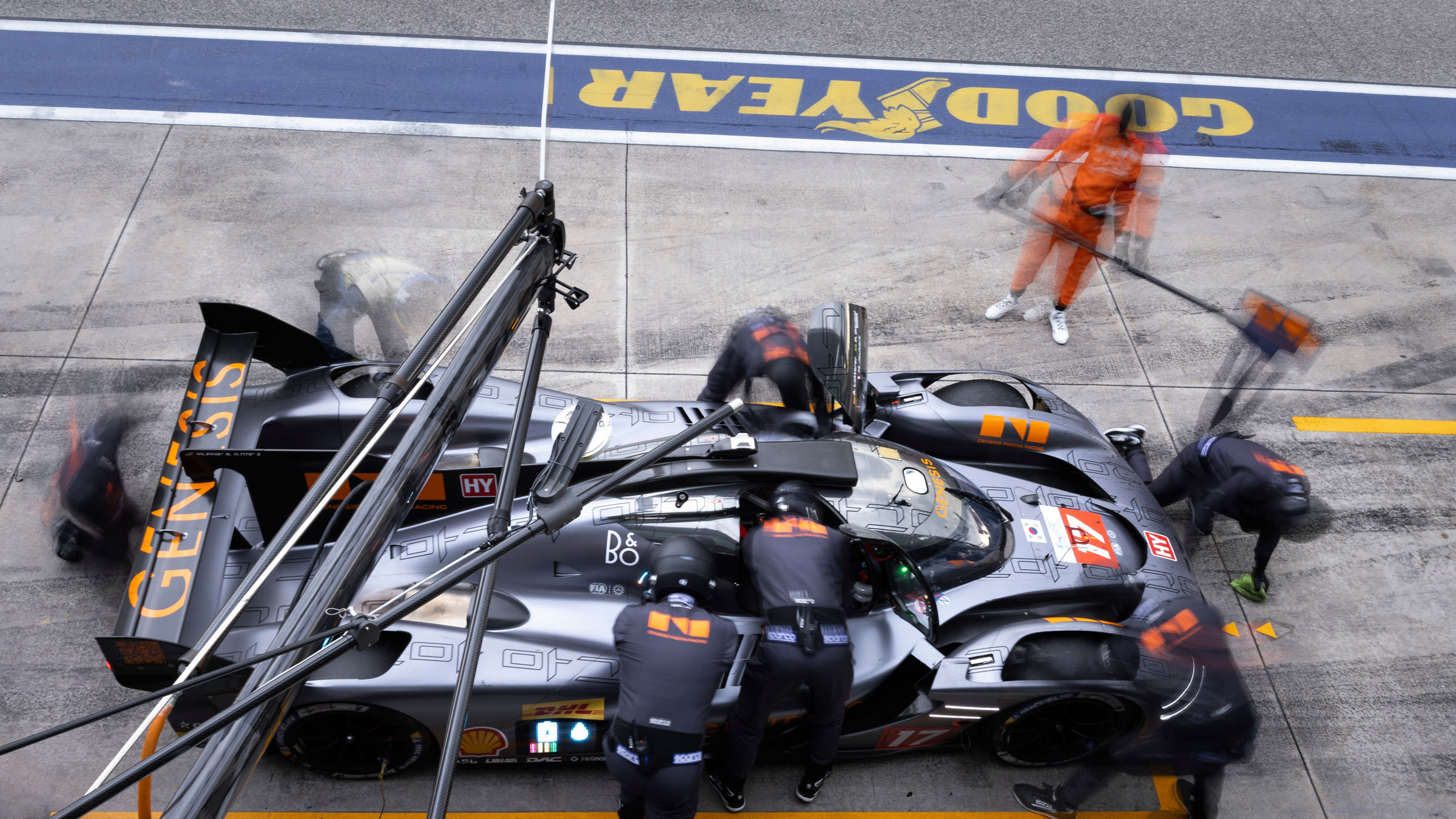 Overhead view of pit crew servicing the Genesis GRM-001 during stop.