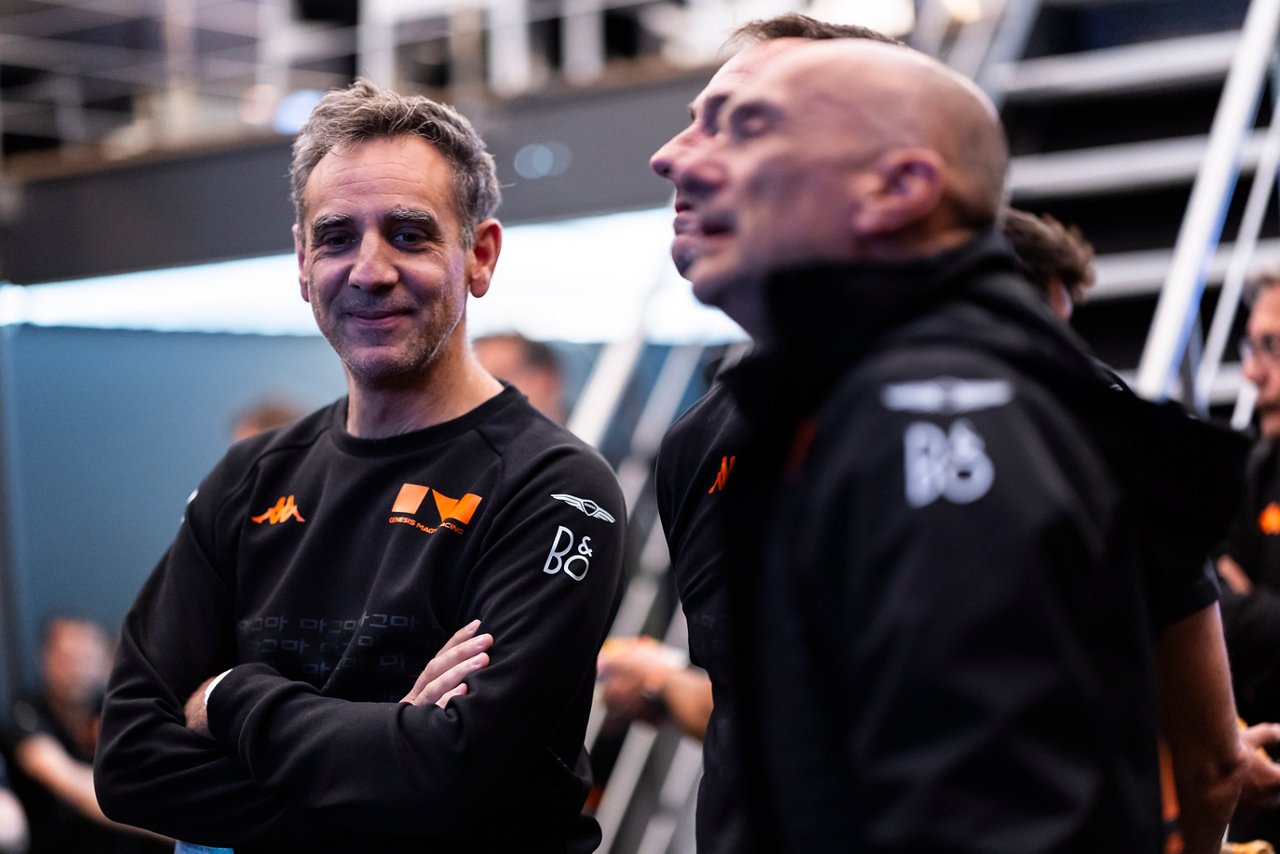 Cyril Abiteboul in a black Genesis Magma Racing apparel stands in garage area at Le Mans.