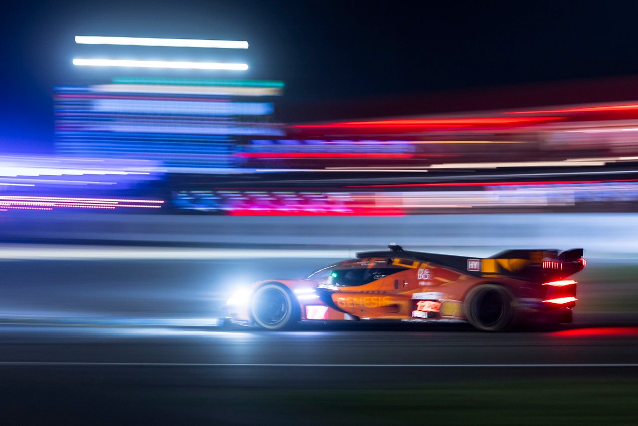 Genesis GRM-001 speeding at night with motion blur and colorful light streaks in the background.