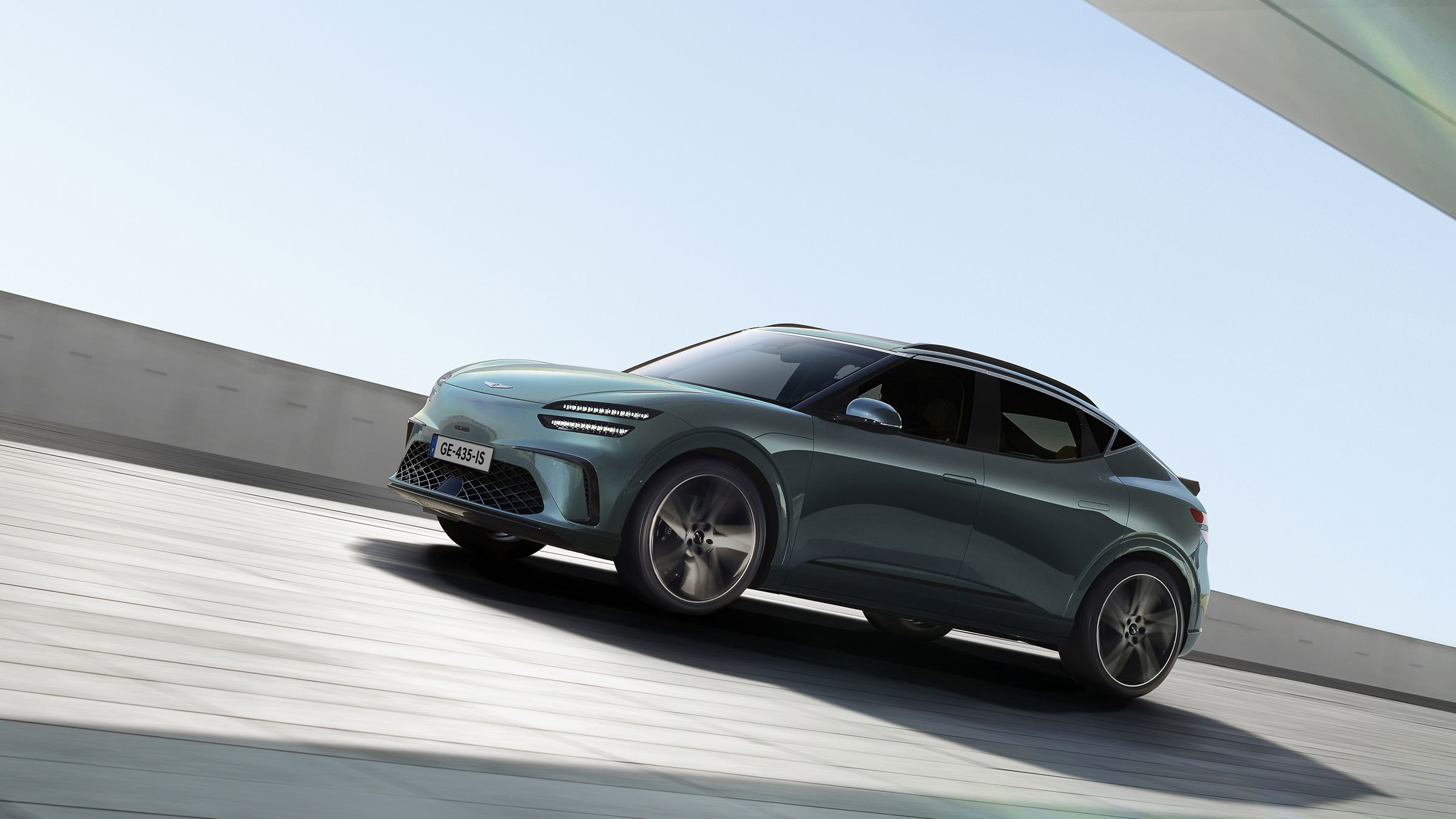 With the blue sky in the background, a Tromso green-colored GV60 is driving toward the side.