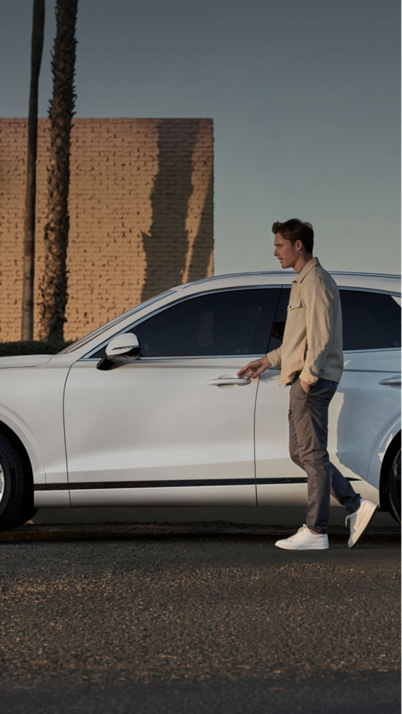 A person walking to open the door of a GV70