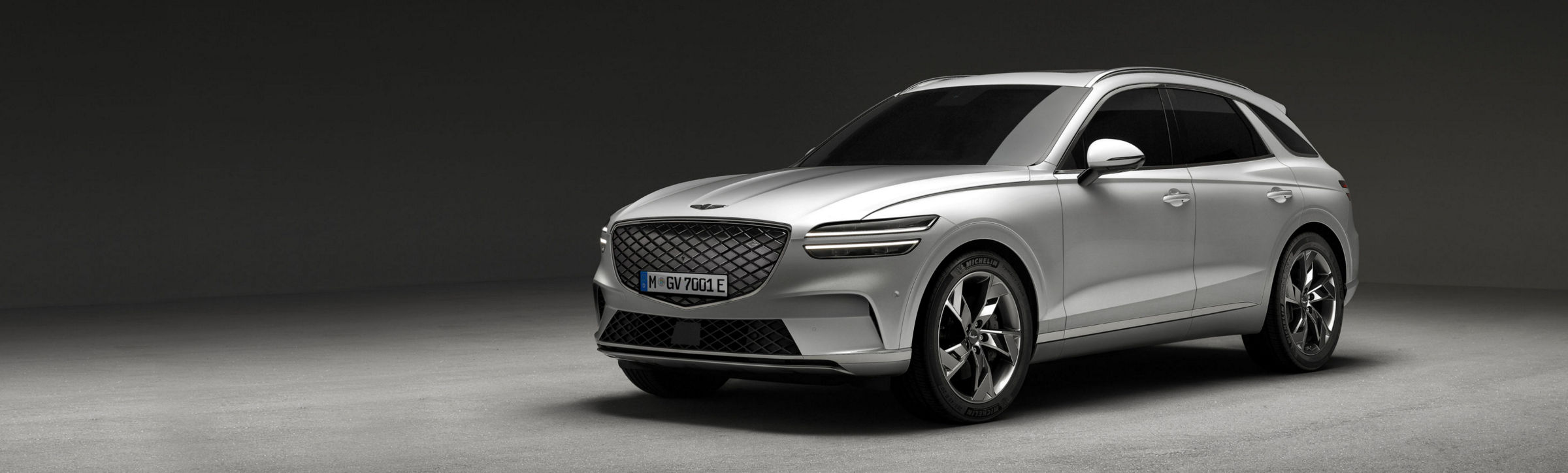 An Genesis Electrified GV70 parked in ample space.