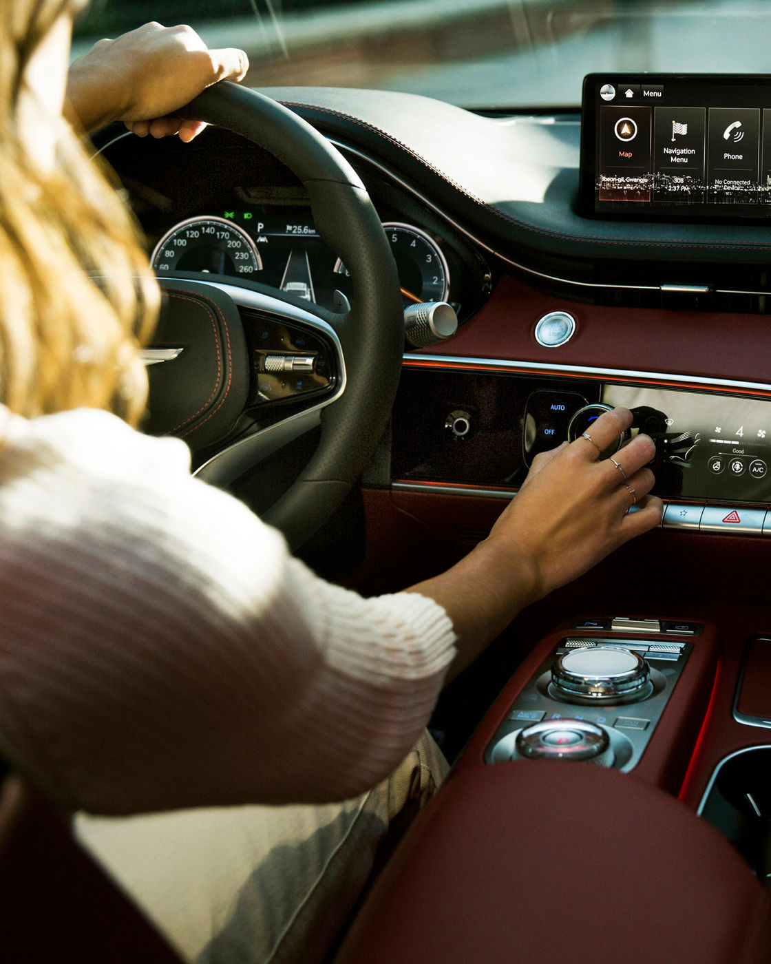 A woman at the wheel of a car switches on the air conditioning