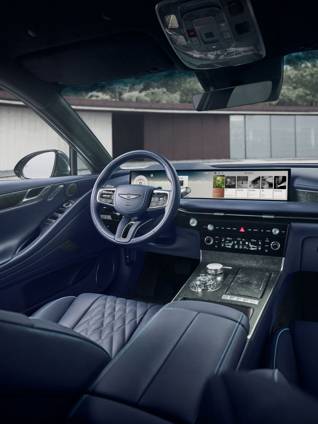 Vertical shot of the Genesis G80 luxury sedan front interior, highlighting the panoramic Connected Car Integrated Cockpit (CCIC) screen.