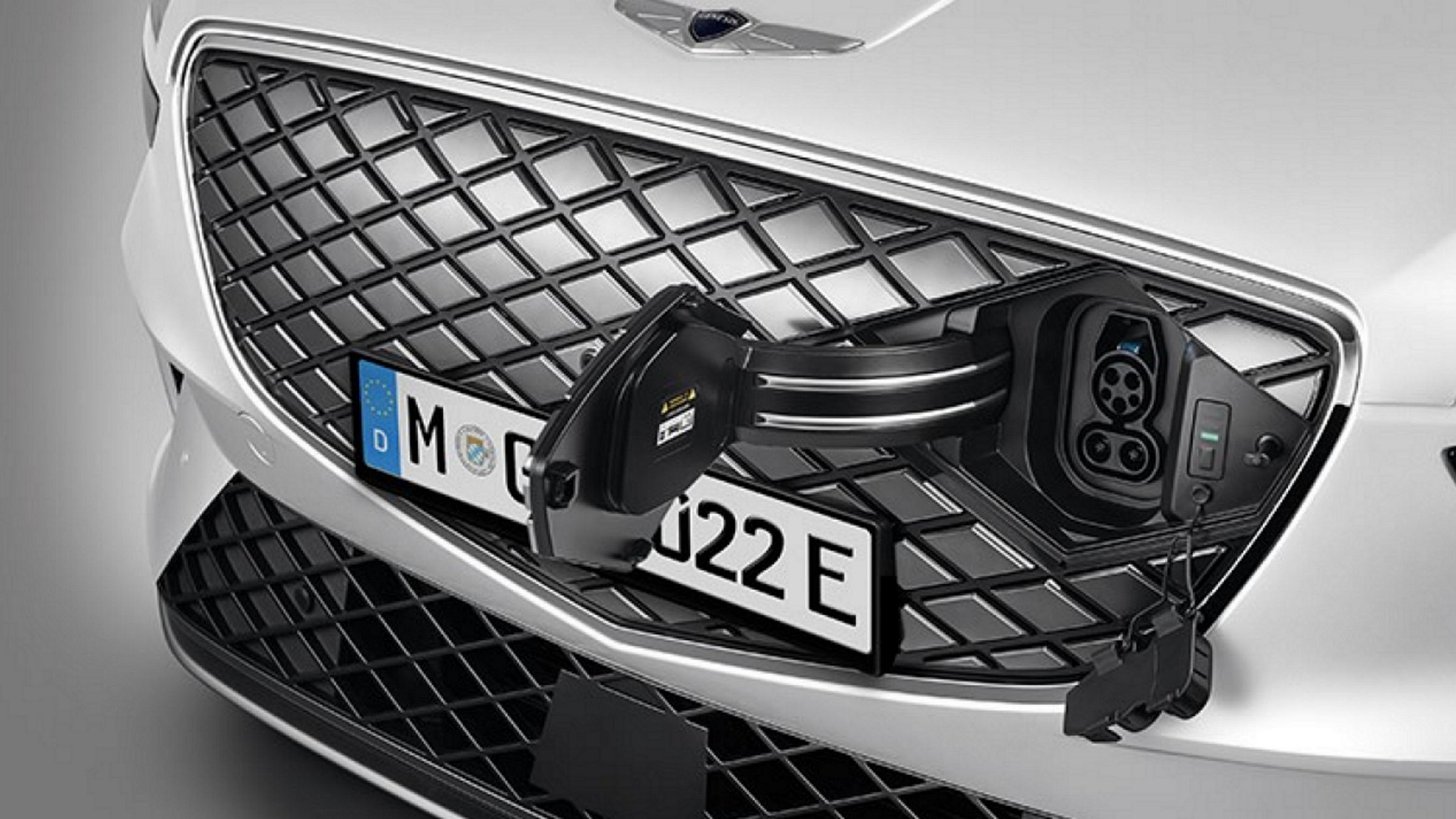 El cargador se inserta en la puerta de carga oculta de la rejilla con patrón G-Matrix del Genesis Electrified GV70.