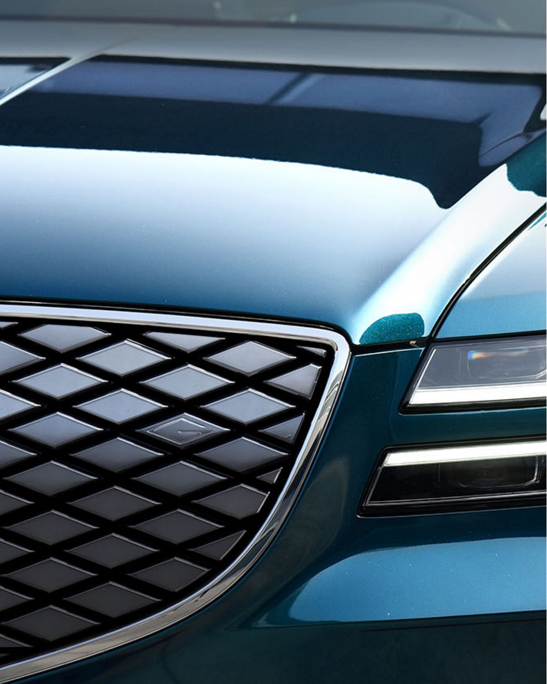 A close-up of the Electrified G80’s signature crest grille and gleaming metallic finish.