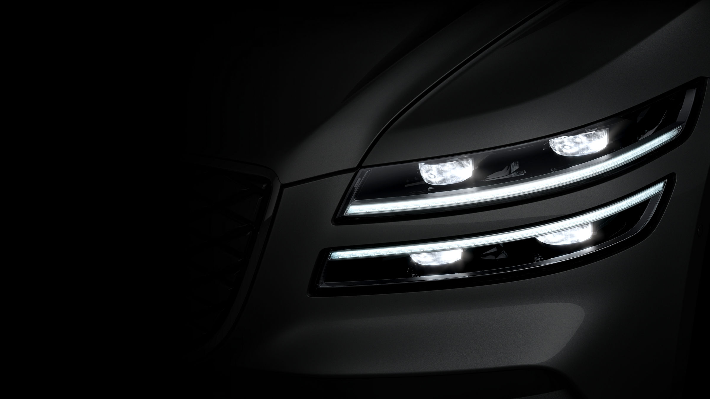 A close-up of the Electrified G80's signature quad headlamps glowing brightly at night.