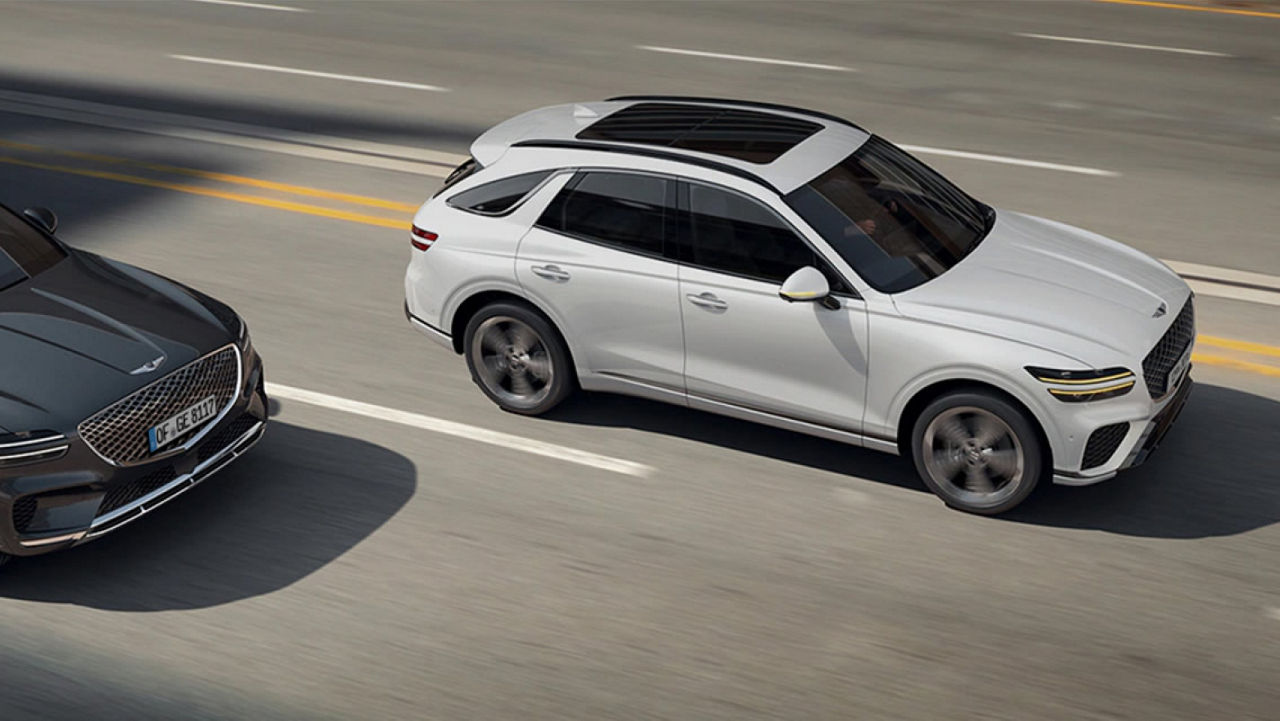 Der Genesis Electrified GV70 fährt auf einer Stadtstraße und zeigt sein dynamisches Profil und aerodynamisches Design