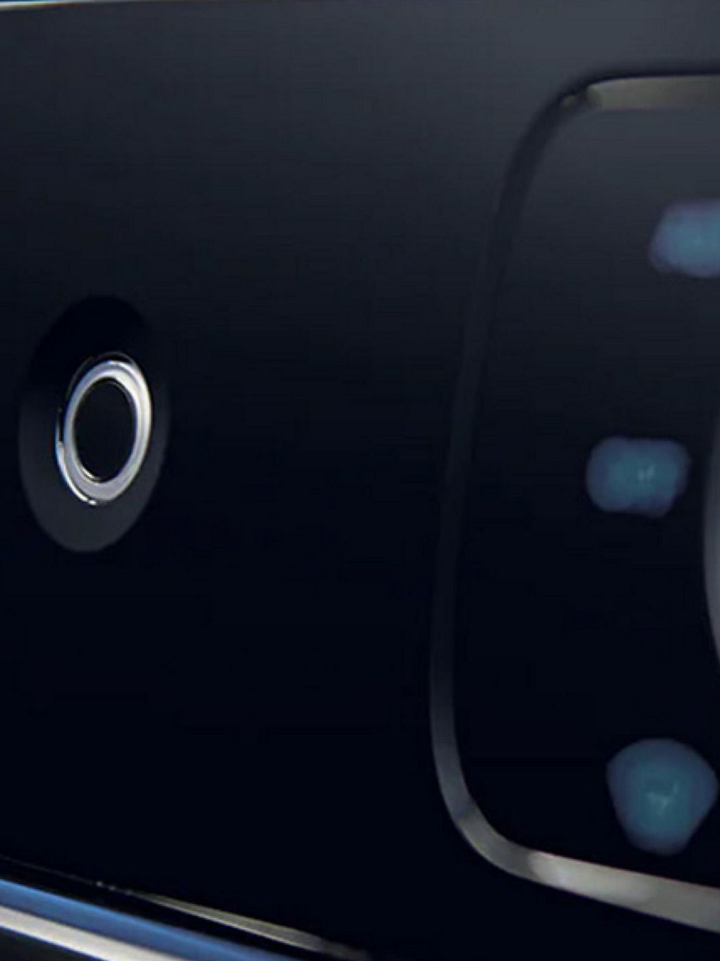 A close-up of a digital button interface with a sleek black surface and integrated technology in a Genesis vehicle.