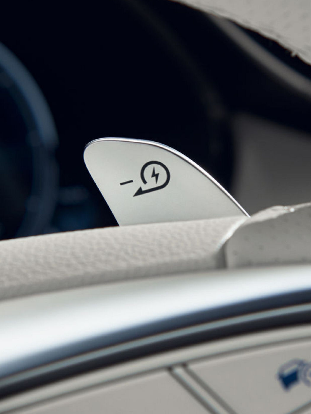 A close-up of a paddle shifter with a symbol indicating regenerative braking in a Genesis vehicle.