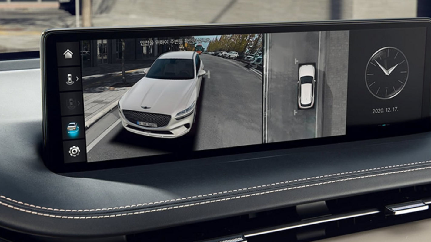 An Electrified Genesis GV70's infotainment screen displaying a 360-degree camera view, enhancing driver awareness and parking precision.