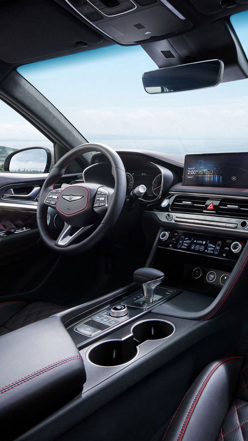 Close-up of the G70 Shooting Brake's steering wheel and dashboard, emphasizing its premium materials and intuitive controls.