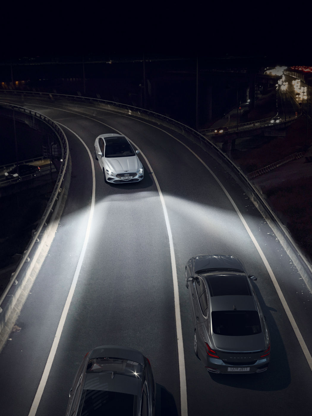 The G70 Shooting Brake driving at night with headlights illuminating the road ahead, showcasing its advanced lighting system.