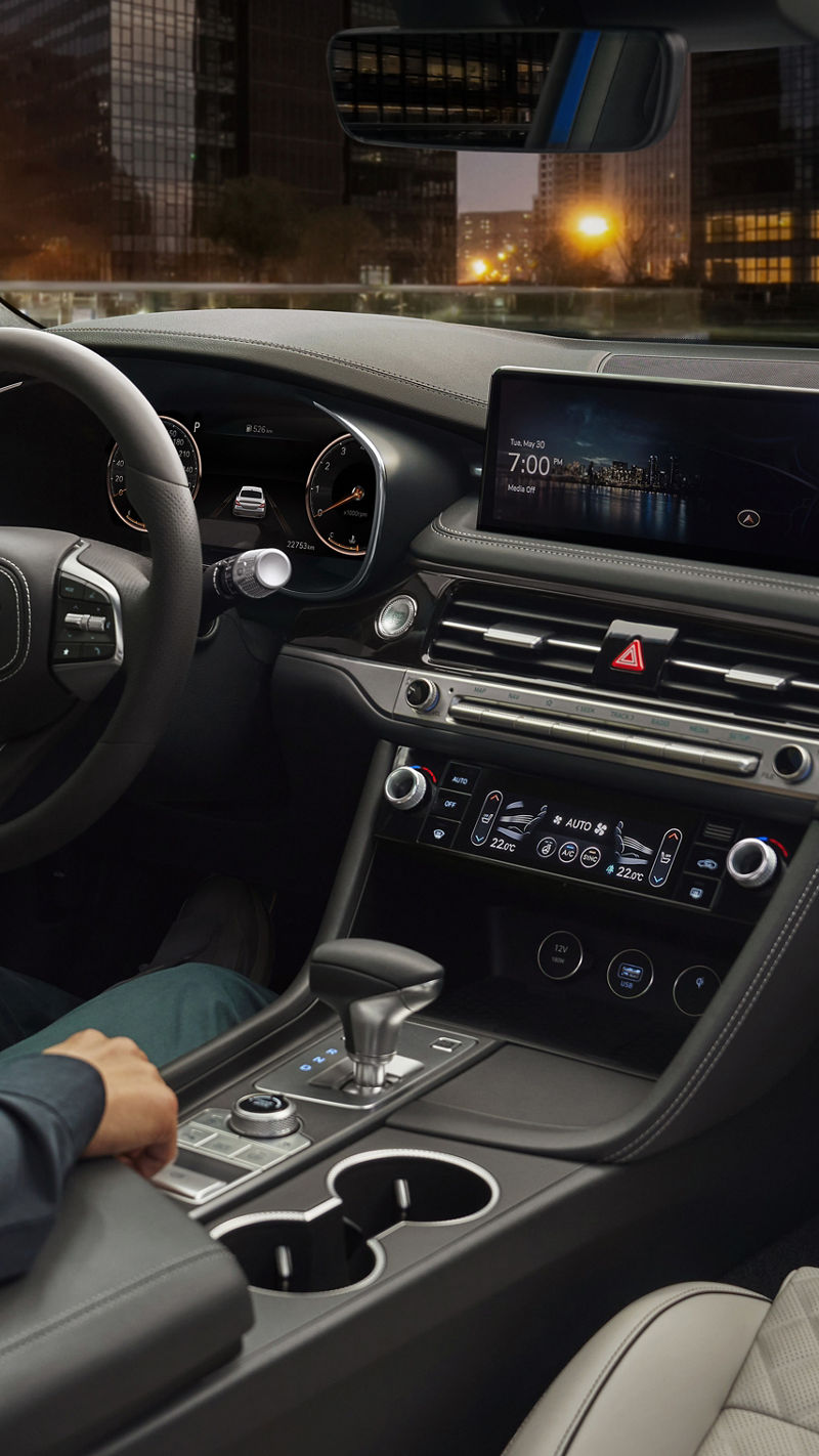 Man at the wheel of the Genesis G70 looks at the display in the centre