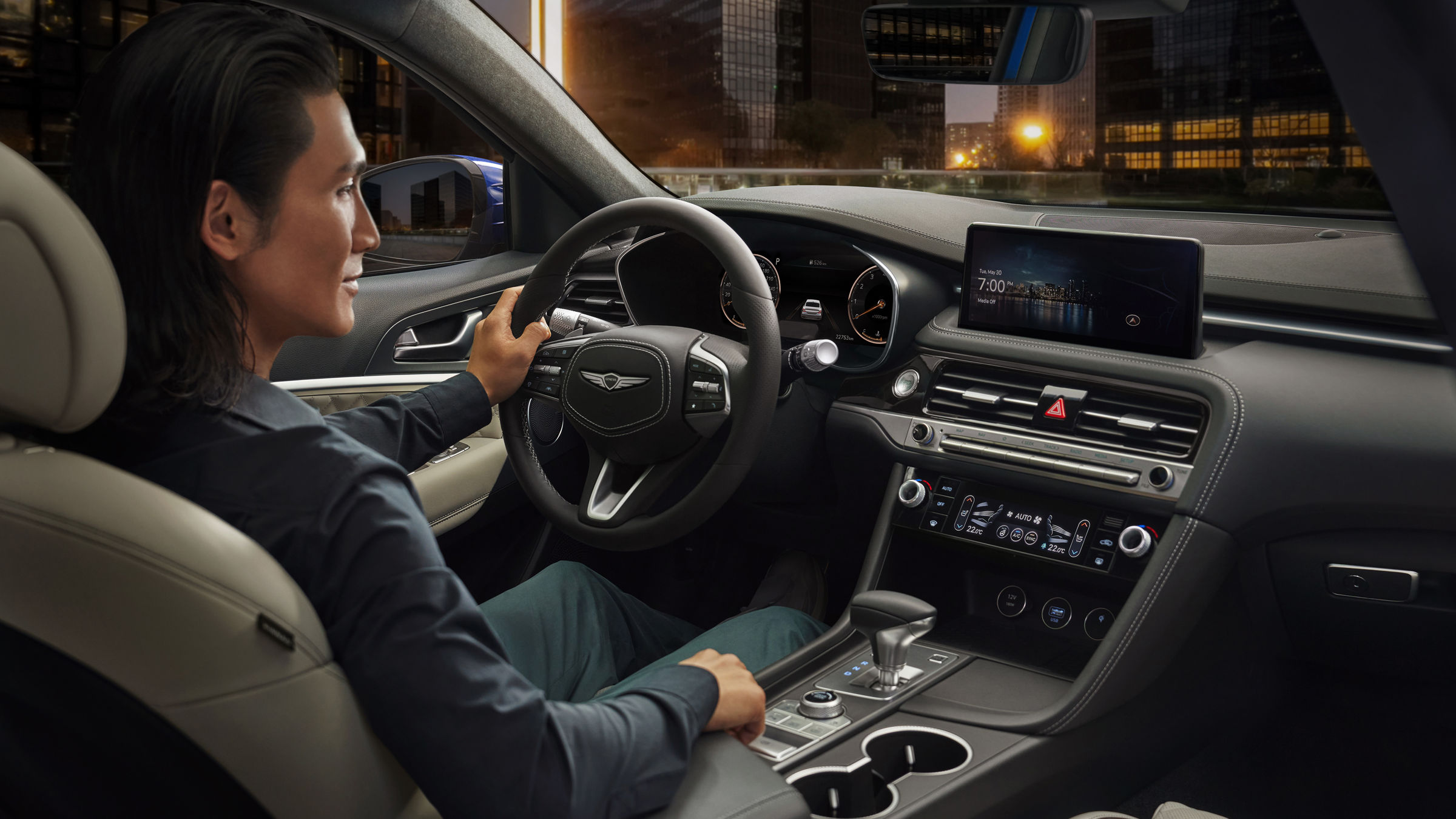 Man at the wheel of the Genesis G70 looks at the display in the centre